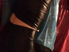 In latex bed with black latex pants and pvc shirt.
